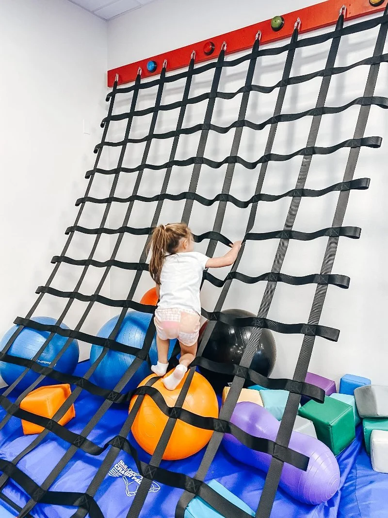 girl climbing an obstacle at we rock the spectrum in forest hill maryland