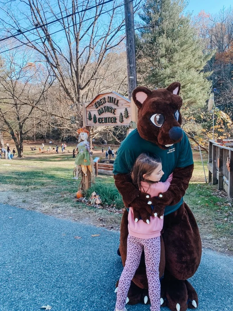 Girl hugging the mascot from Eden Mill Nature Center at their annual Fall Fest in Pylesville, MD