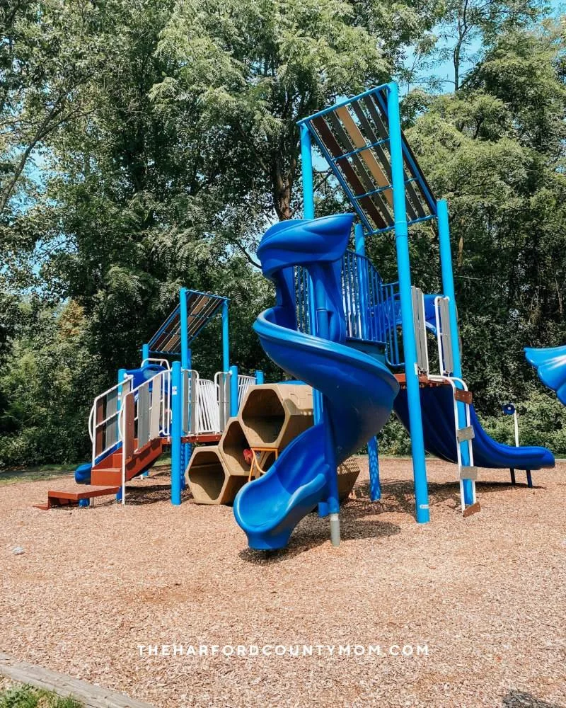 Blue spiral slide structure and climbing elements shown at Mariner Point Park playground in Joppatowne, MD