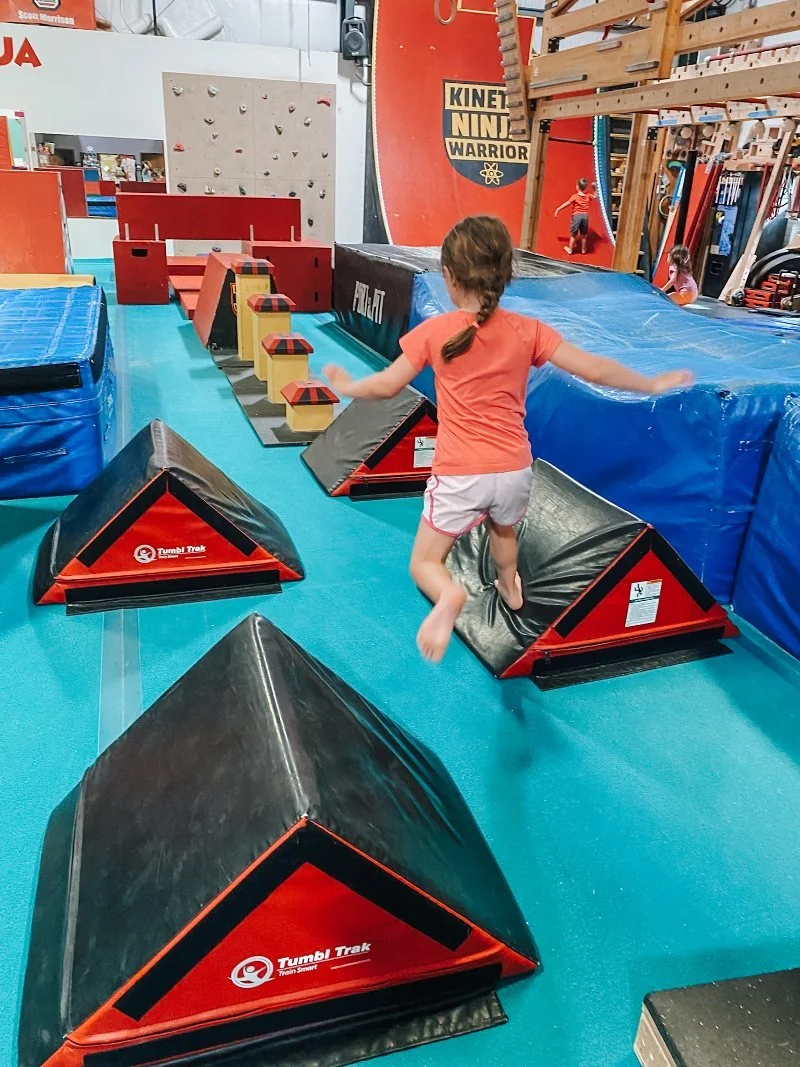 girl completing a ninja warrior obstacle at kinetic ninja warrior in bel air maryland