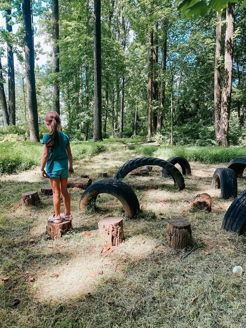 girl standing on a log at the bear legacy adventure trail in harford county maryland
