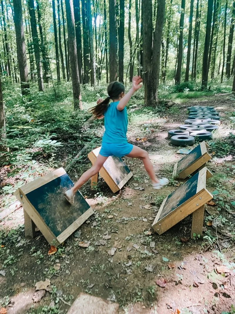 girl completing obstacle course at the bear legacy adventure trail in harford county