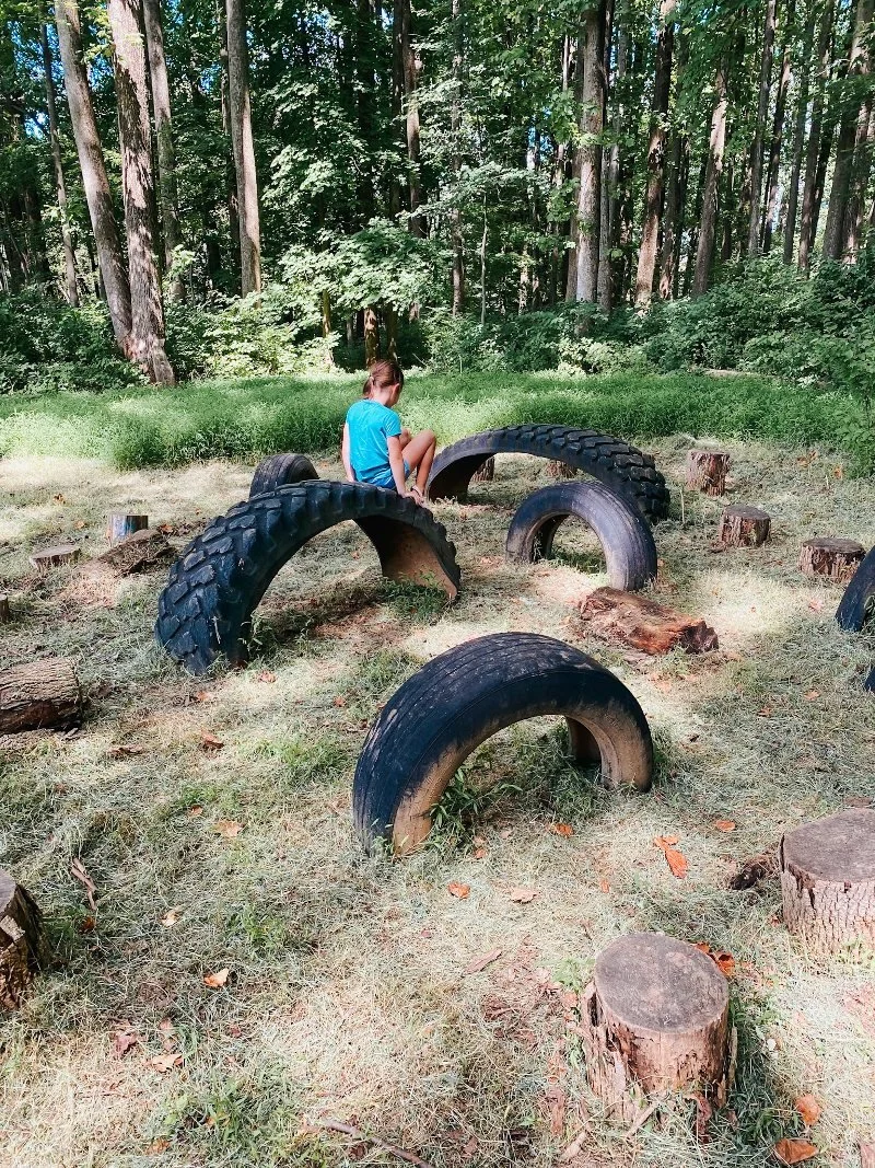 girl climbing tires at the bear legacy adventure trail in bel air, md