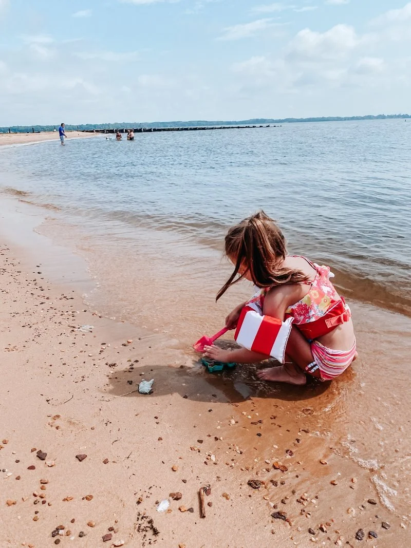 girl playing on the sandy shoreline of hammerman beach located within Gunpowder Falls State Park