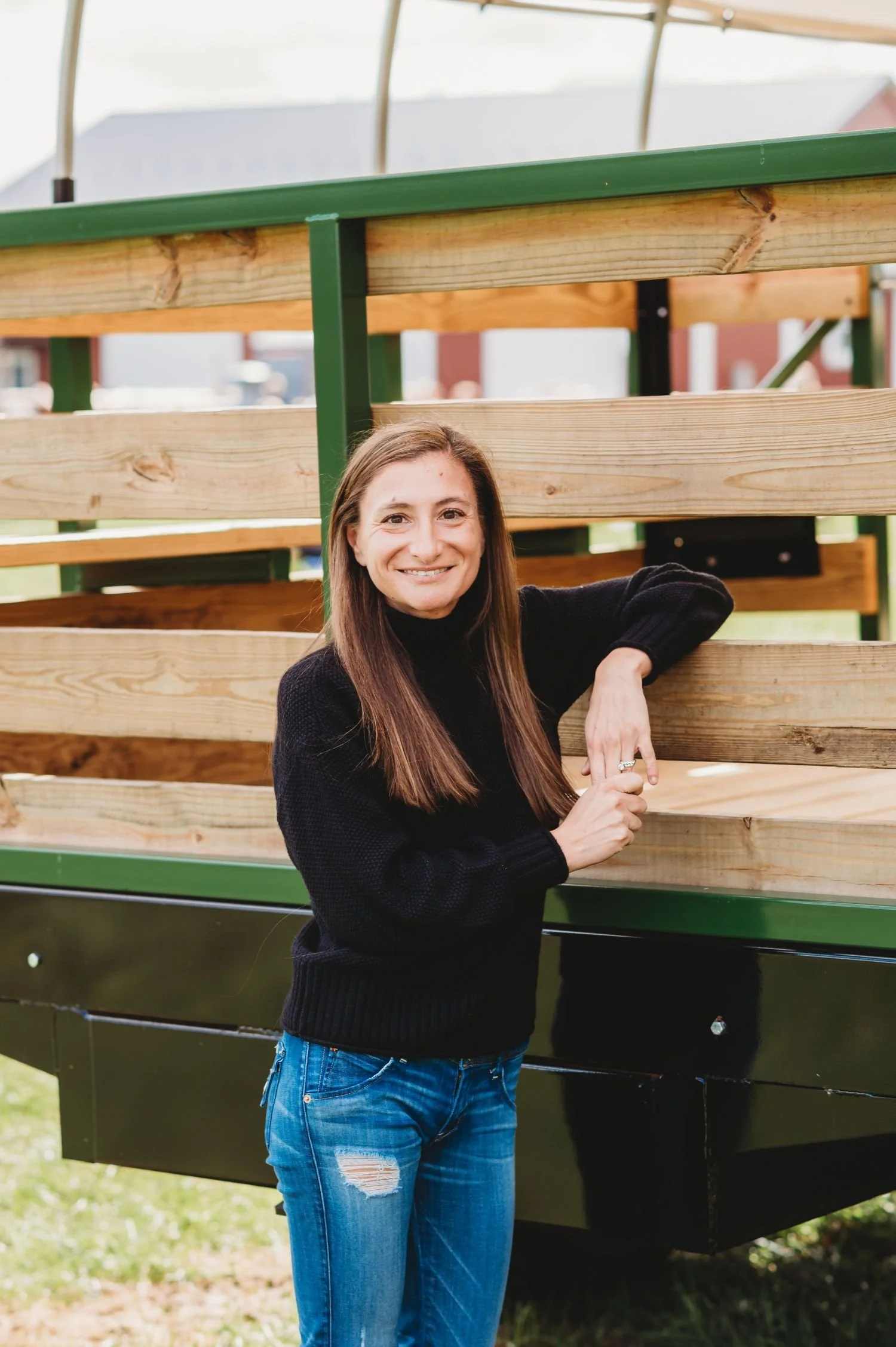 Ange, The Harford County Mom, stands with arm resting against farm truck introducing herself to her local community