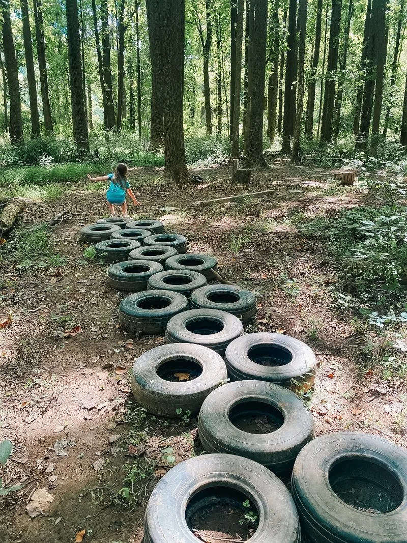 girl jumping along a tire path at the bear legacy trail in bel air maryland