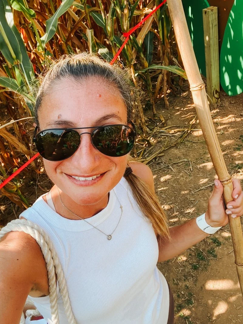 Ange wears sunglasses and takes a selfie in the Beachmont Corn Maze in Kingsville, MD where they have kids play areas and activities as well as hayrides in 2026