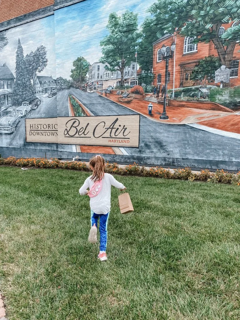 girl running towards the downtown bel air sign