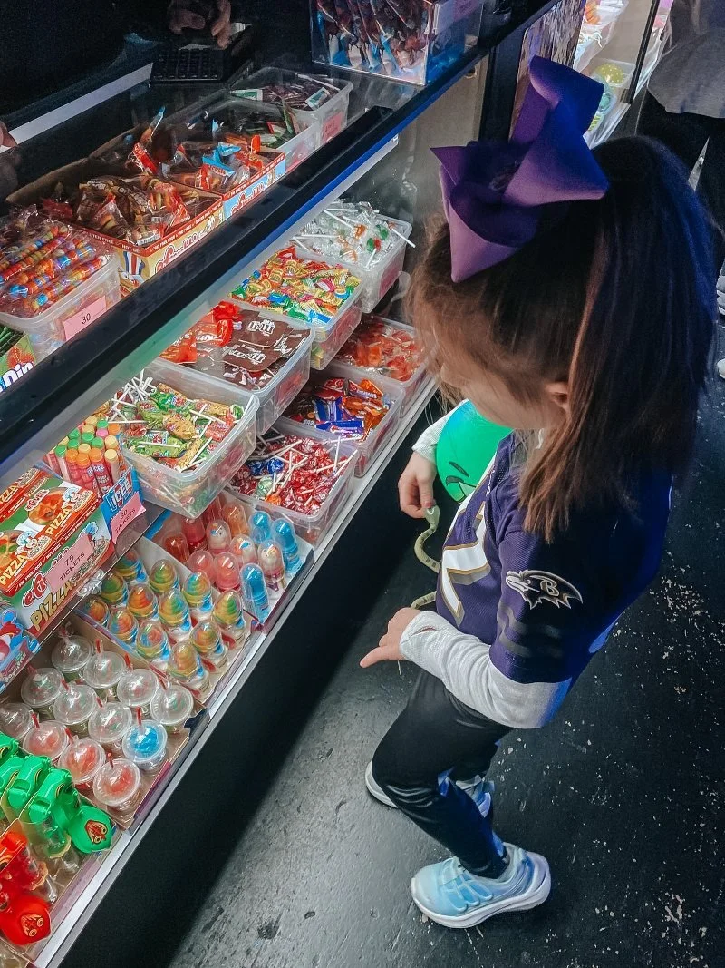 girl picking a prize from the prize counter at jurassic golf and arcade in bel air, maryland