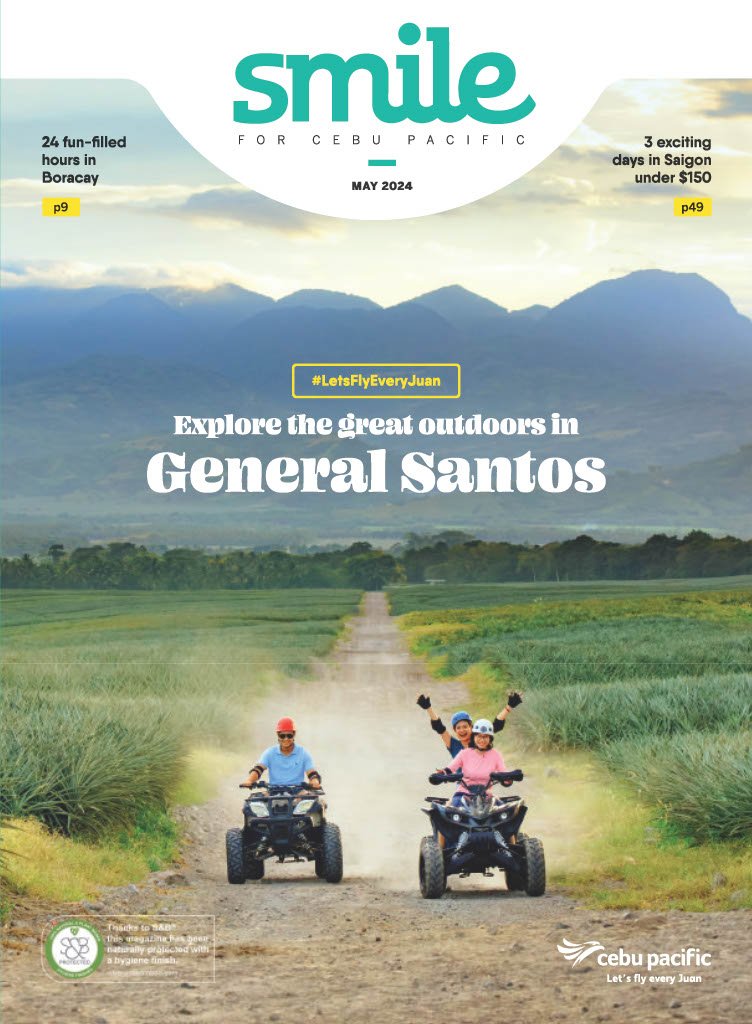Three children riding all-terrain vehicles on a dirt path through greenery with mountains in the background during daytime.