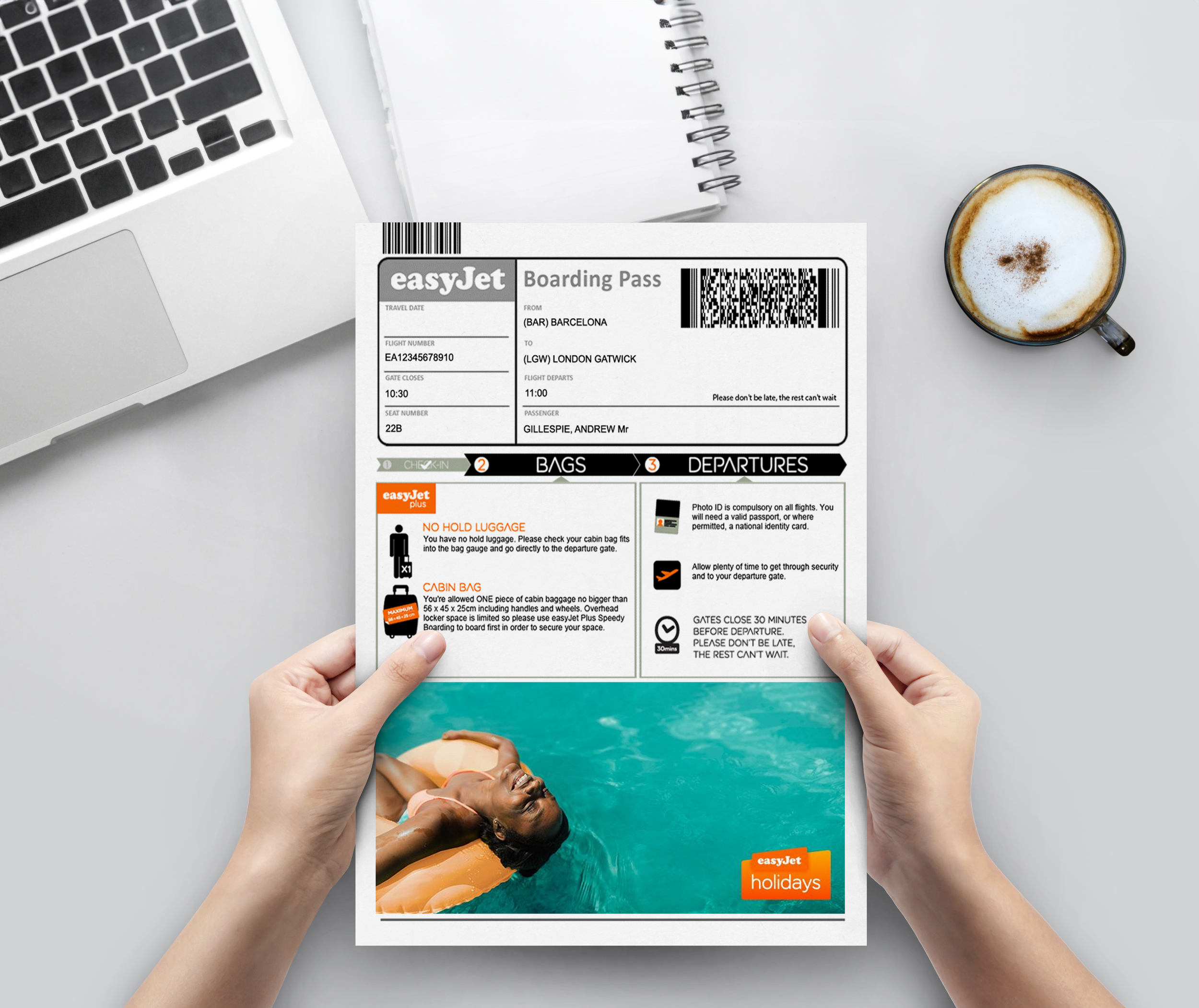 An airplane boarding pass, a laptop, a spiral notebook, and a cup of coffee on a white desk, with hands holding the boarding pass.