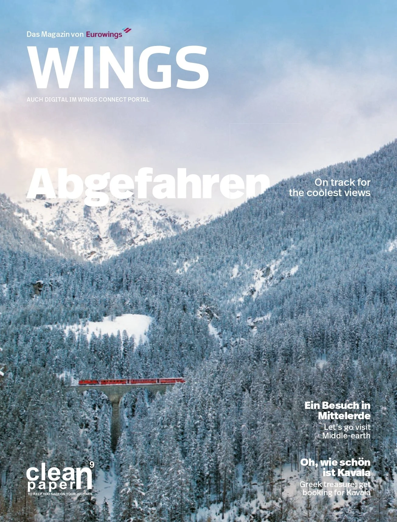 A snowy mountain landscape with a red train traveling on a bridge over a forested valley, magazine cover in German and English about travel and scenic views.