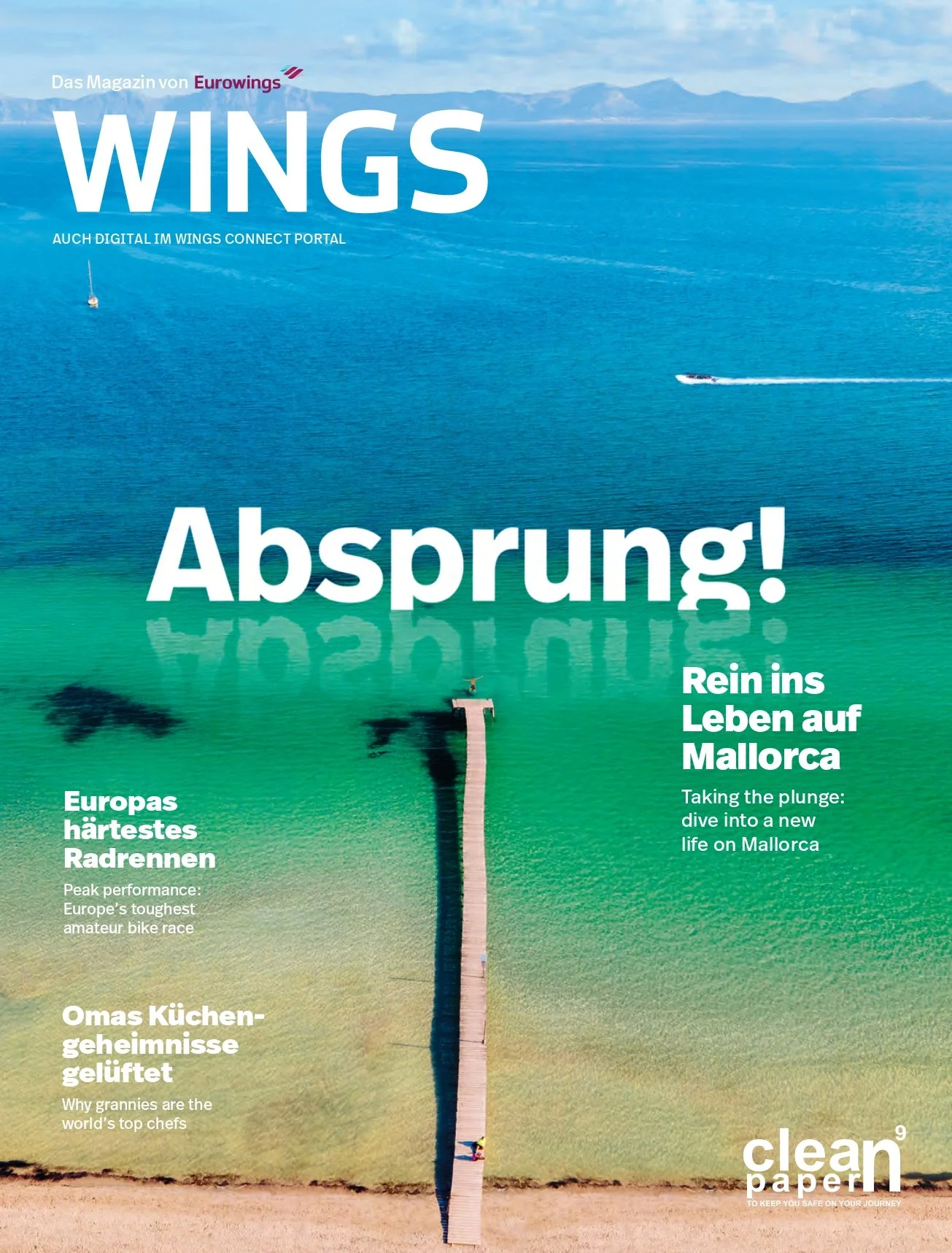 Cover of WINGS magazine featuring an aerial view of a wooden pier extending into a turquoise sea, with mountains in the background and a boat speeding across the water.