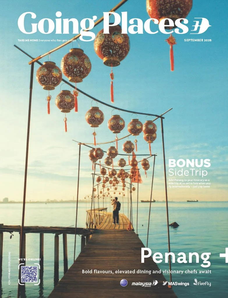 A magazine cover titled 'Going Places' featuring a wooden pier over water decorated with hanging lanterns.