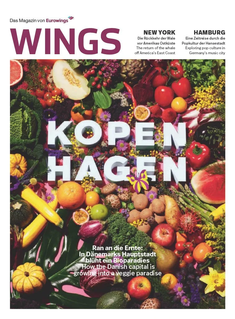 Cover of WINGS magazine showcasing a colorful arrangement of fresh fruits, vegetables, and flowers with bold white text reading "KOPEN HAGEN" and additional headlines about New York and Hamburg.