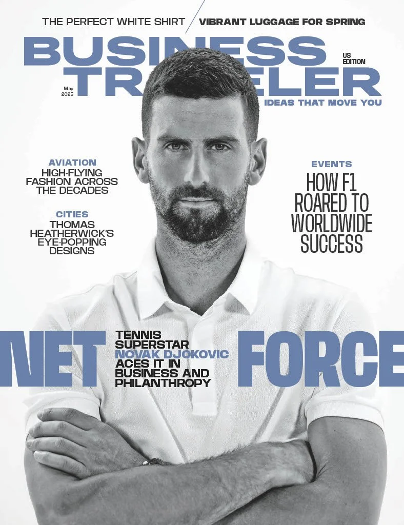 Cover of a magazine titled "Business Traveller" May 2025, featuring a black and white photo of Novak Djokovic with arms crossed, wearing a white shirt. Headlines include "Vibrant Luggage for Spring," "The Perfect White Shirt," and articles on aviation, cities, events, and tennis superstar Novak Djokovic promoting business and philanthropy.
