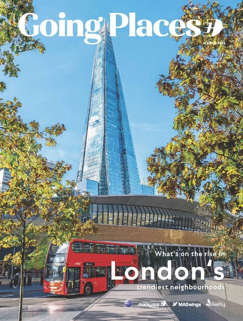 Cover of Going Places magazine, March 2024 edition, featuring a tall modern glass skyscraper viewed from ground level, framed by green trees, with a red double-decker bus in front, and the headline "What's on the rise in London's trendiest neighbourhoods".