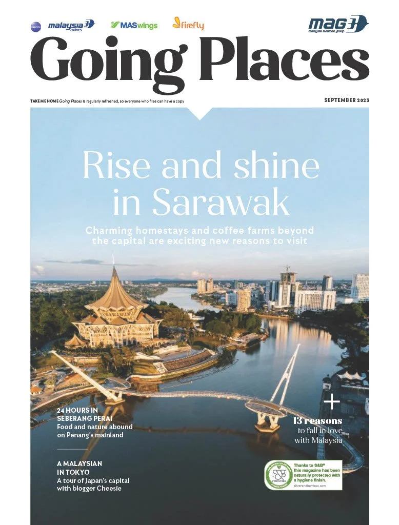 Magazine cover titled "Going Places" with a main feature about Sarawak, Malaysia, highlighting its charming homestays and coffee farms, with an aerial view of a cityscape and river. The cover also mentions other travel stories and has logos of Malaysian airlines at the top.