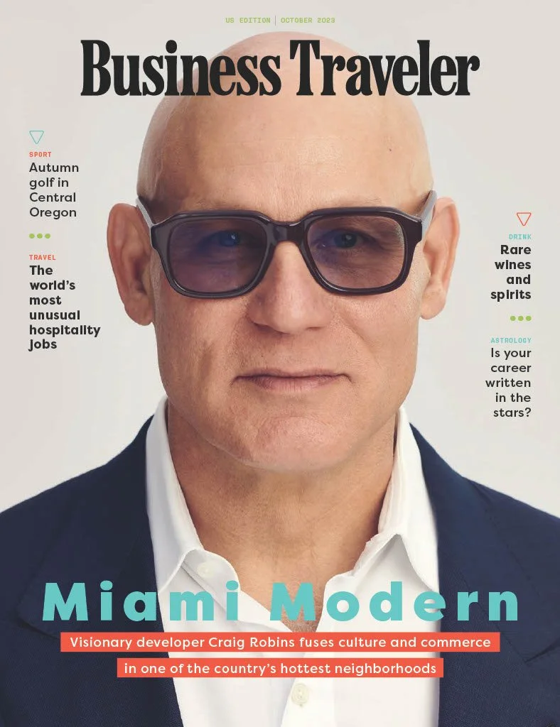 Front cover of Business Traveler magazine, October 2023 issue featuring a close-up of a bald man with glasses in a suit. Headlines include topics on autumn golf in Central Oregon, unusual hospitality jobs, rare wines and spirits, astrology, and a feature on Craig Robins in Miami.