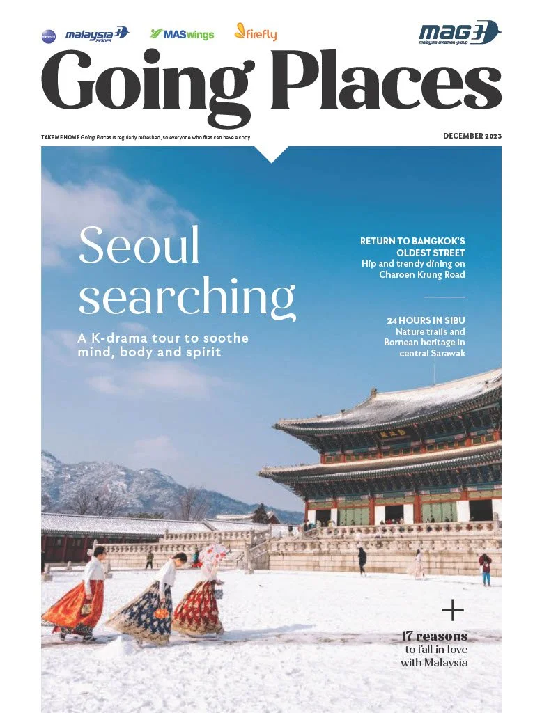 Cover of a magazine titled 'Going Places,' December 2023 issue, featuring a winter scene at Gyeongbokgung Palace in Seoul, South Korea, with people in traditional clothing walking in the snow.