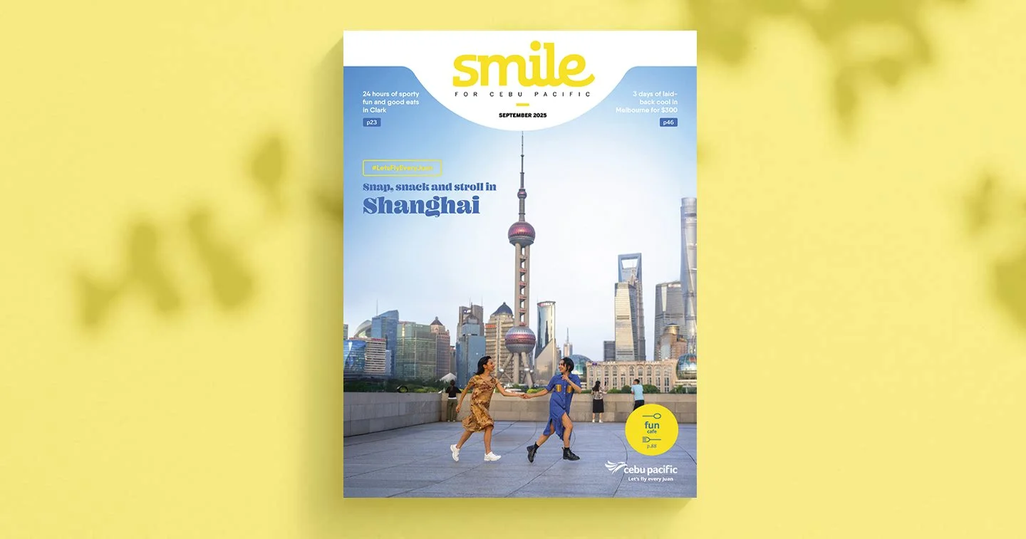 Cover of a Cebu Pacific magazine titled "Smile" with a skyline of Shanghai, featuring the Oriental Pearl Tower, and two women running and holding hands in the foreground.