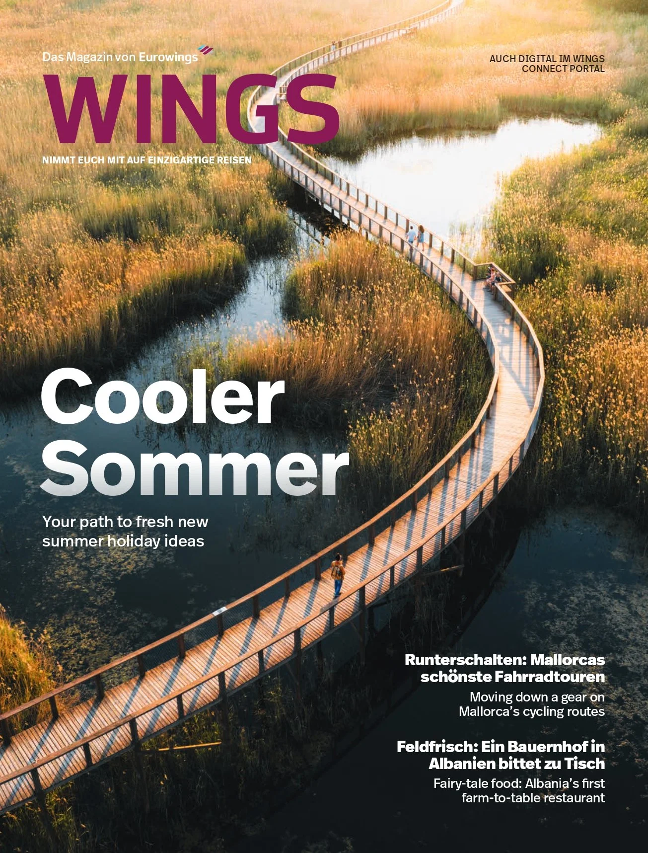 Cover of a magazine titled 'WINGS' with a winding wooden bridge over marshland at sunset, featuring a few people walking on the bridge.