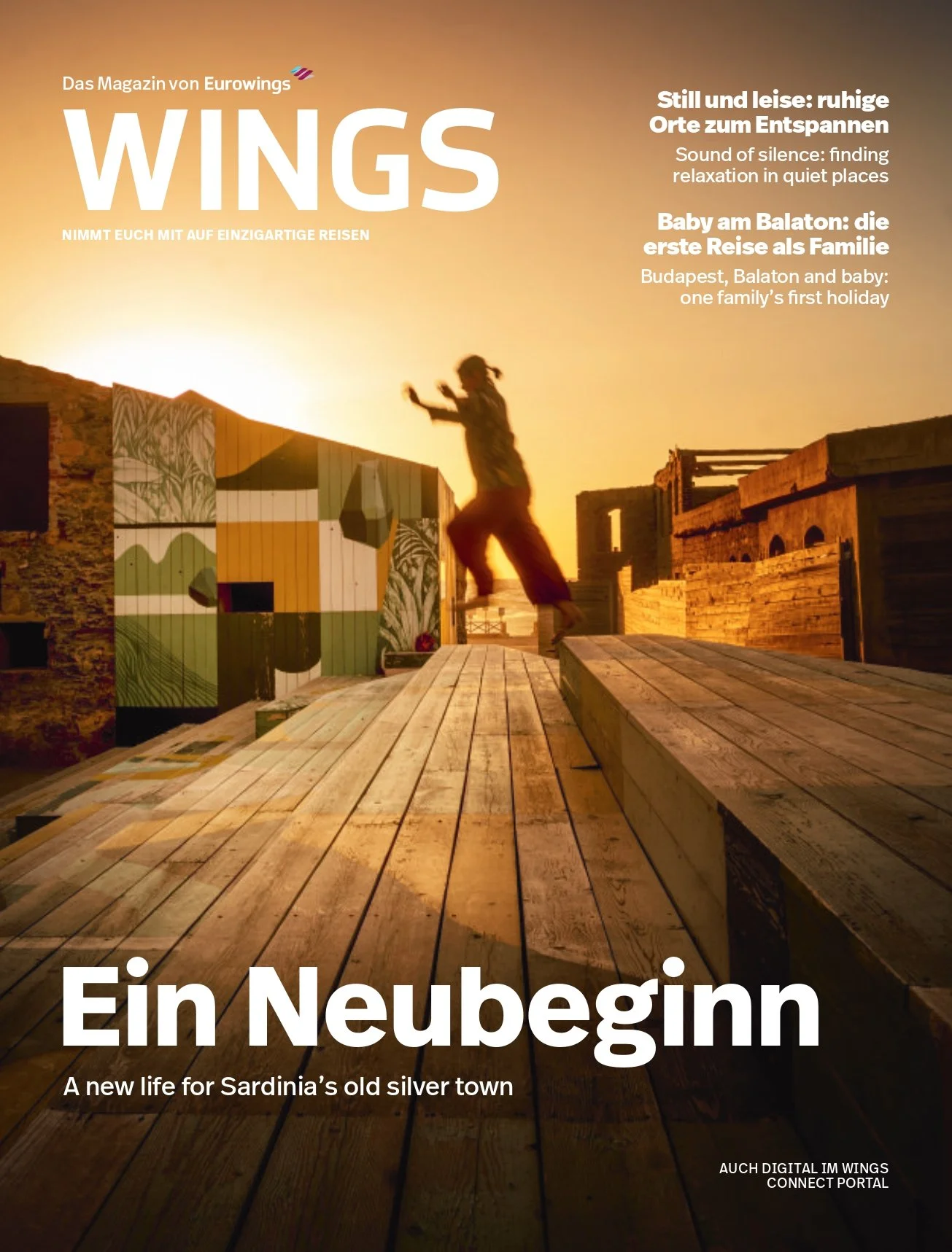 A person jumping on a wooden deck at sunset in a historic town with old buildings and colorful mural walls, promoting travel in Sardinia.