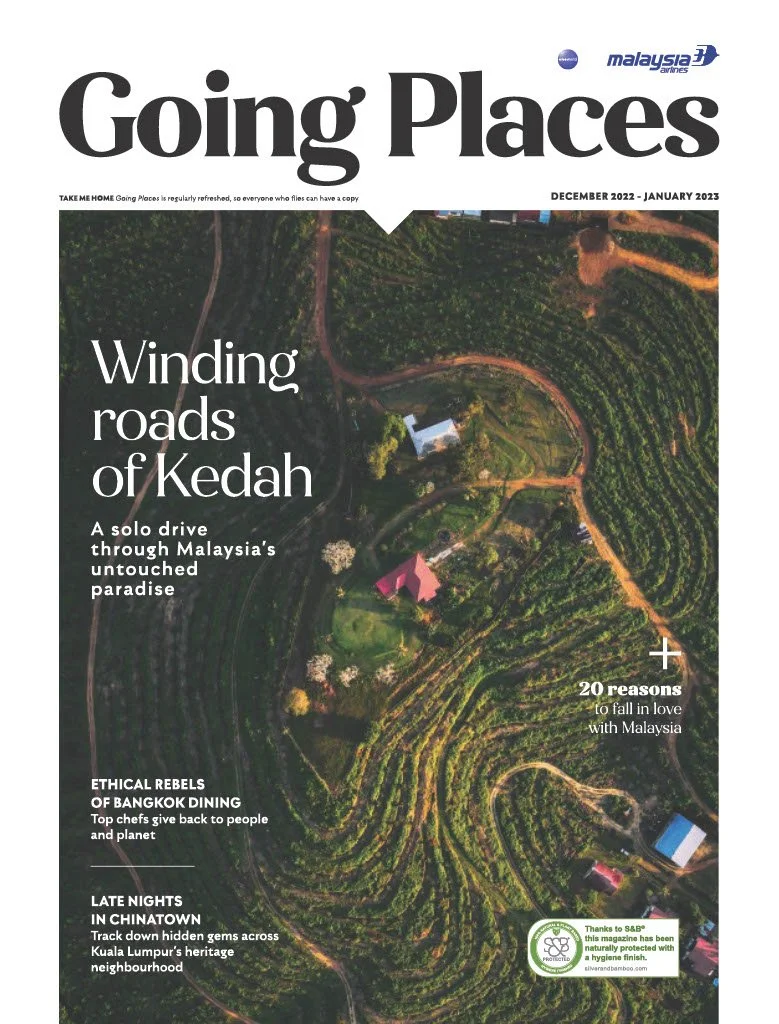 Cover of 'Going Places' magazine featuring an aerial view of winding roads through greenery and houses in Kedah, Malaysia, December 2022 - January 2023 edition.