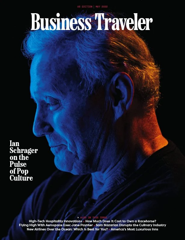 Cover of Business Traveler magazine, May 2022 issue, featuring a profile on Ian Schrager with a close-up side profile of an elderly man with gray hair, illuminated in blue and orange lighting.