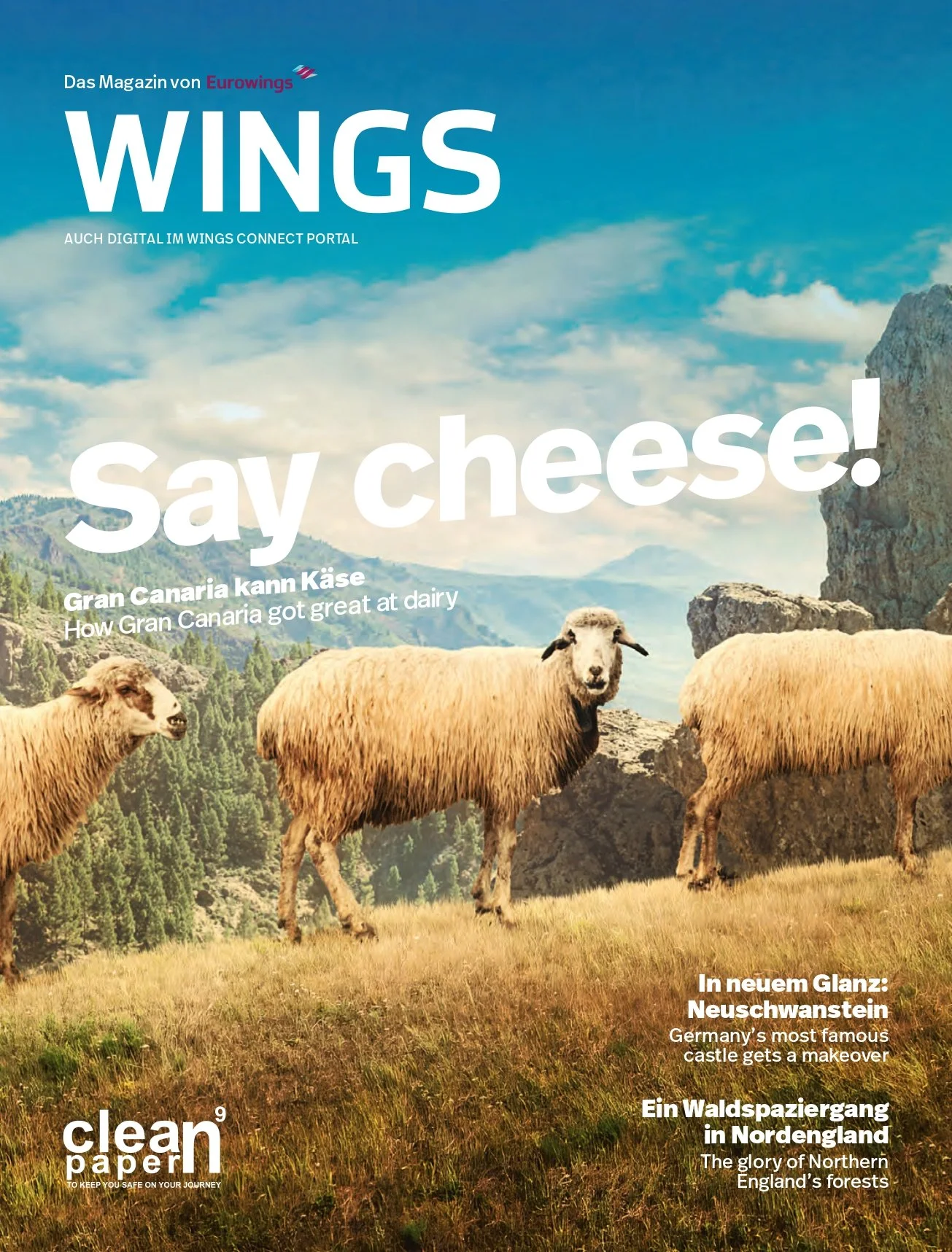 Magazine cover featuring a hill landscape with three sheep, mountains, and a blue sky with clouds. The cover has the title "WINGS" and headlines about dairy in Gran Canaria, a castle in Germany, and a forest walk in Northern England.
