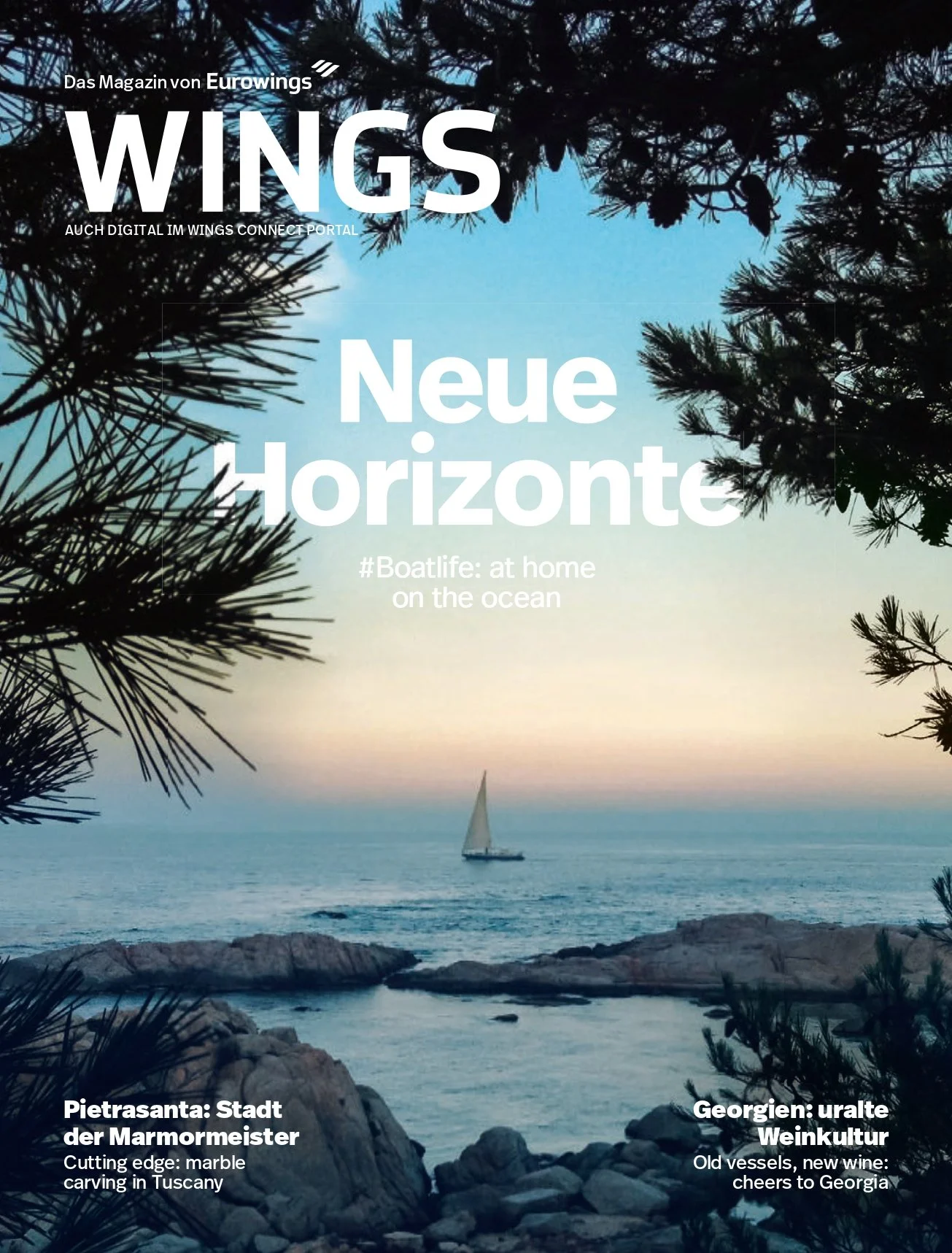 Magazine cover titled "WINGS" featuring a scenic coastal landscape with rocks and a sailboat on the ocean at sunset, framed by pine tree branches.