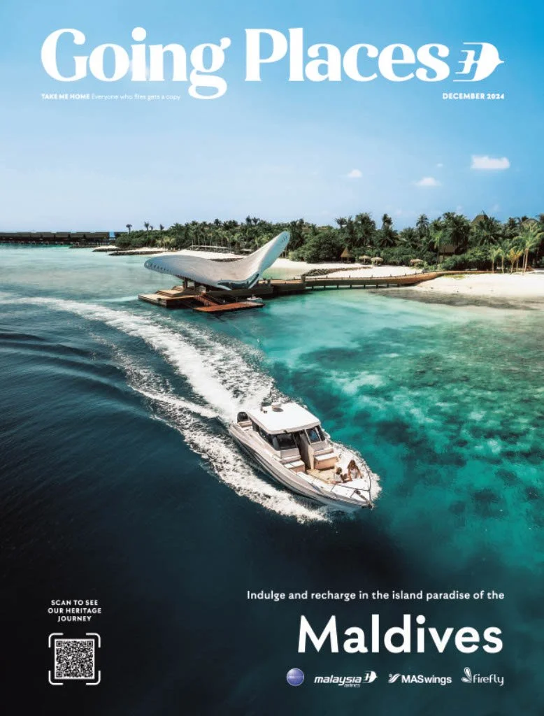 A luxury boat in blue waters approaching an airplane on a floating platform near a tropical island with palm trees, promoting travel to the Maldives.
