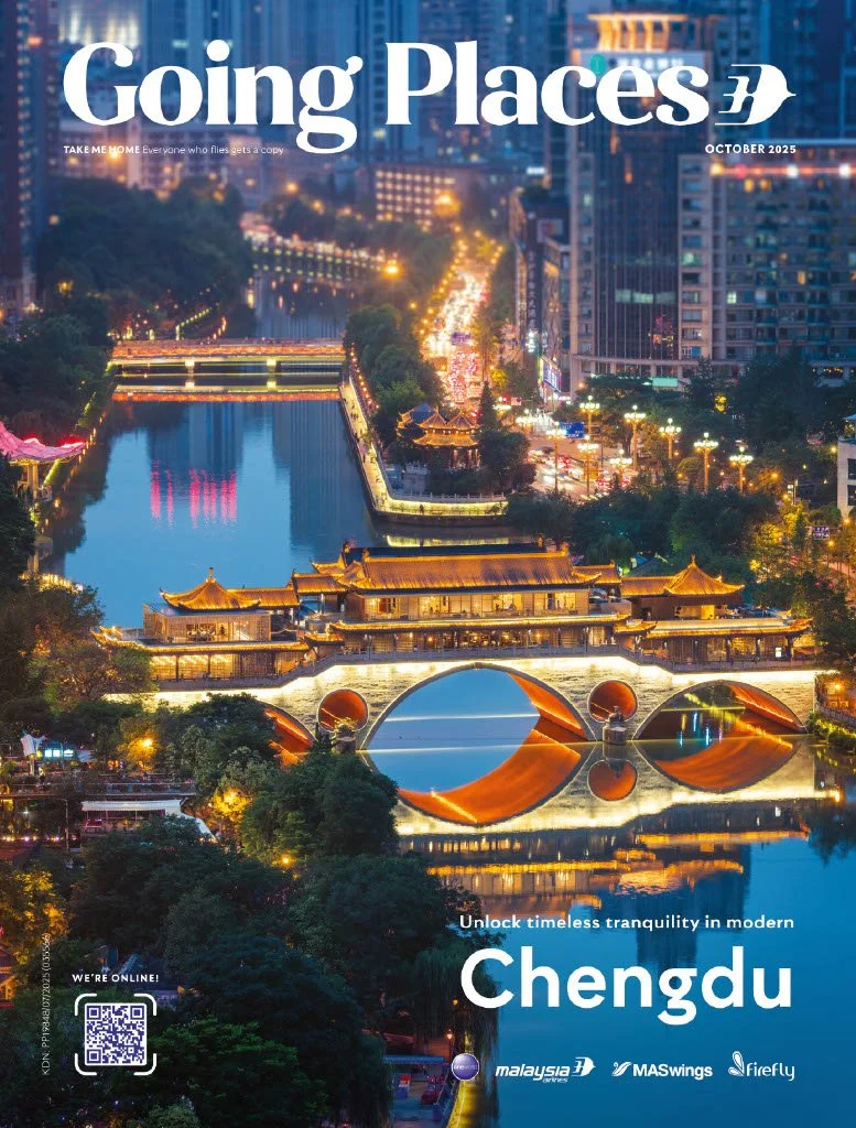 Night view of Chengdu cityscape with illuminated traditional architecture over a river with reflections, modern buildings, and busy streets.