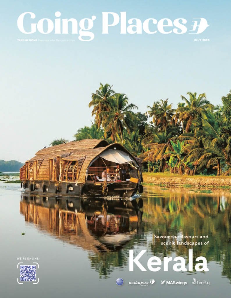 A houseboat on a calm river with lush tropical trees in Kerala, India, during daytime