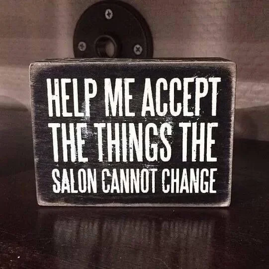 Help me accept the things the salon cannot change," placed on a dark surface with a speaker in the background.