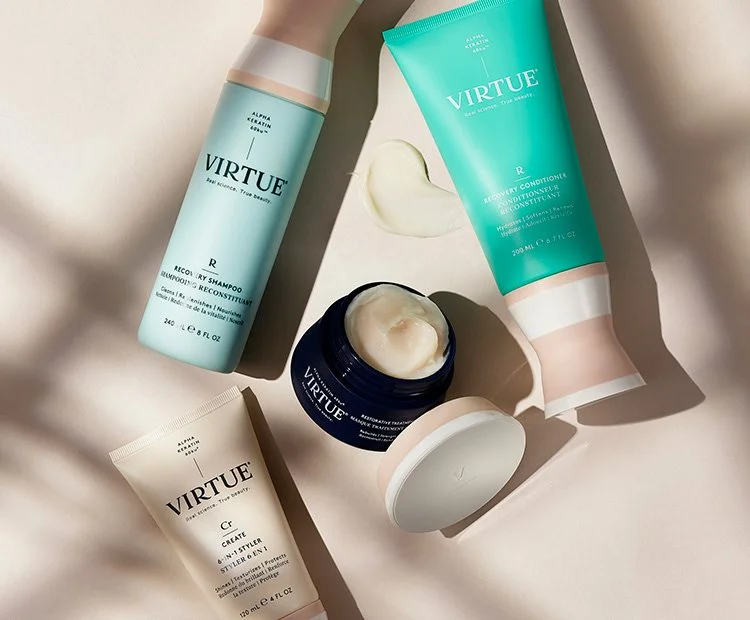 Virtue hair care products including shampoo, conditioner, and styling cream on a white surface with soft lighting.