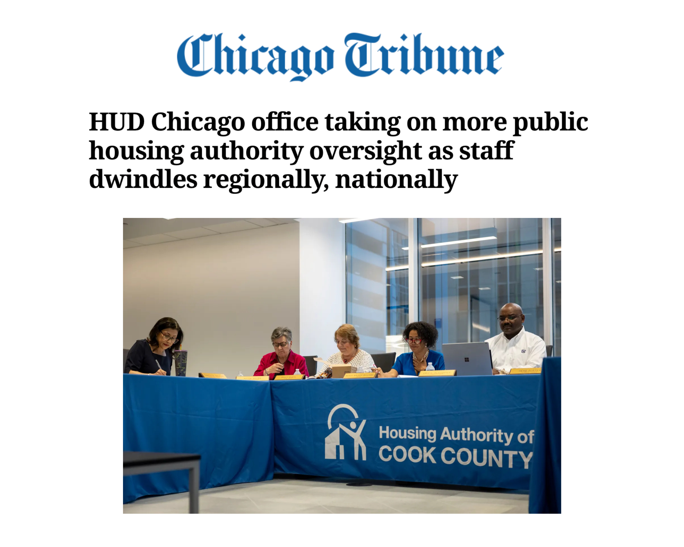 A group of five people sitting at a long table with a blue tablecloth that reads 'Housing Authority of Cook County.' The setting appears to be a meeting or press conference, with a large window in the background. The headline on the page mentions HUD Chicago office oversight of public housing authority.