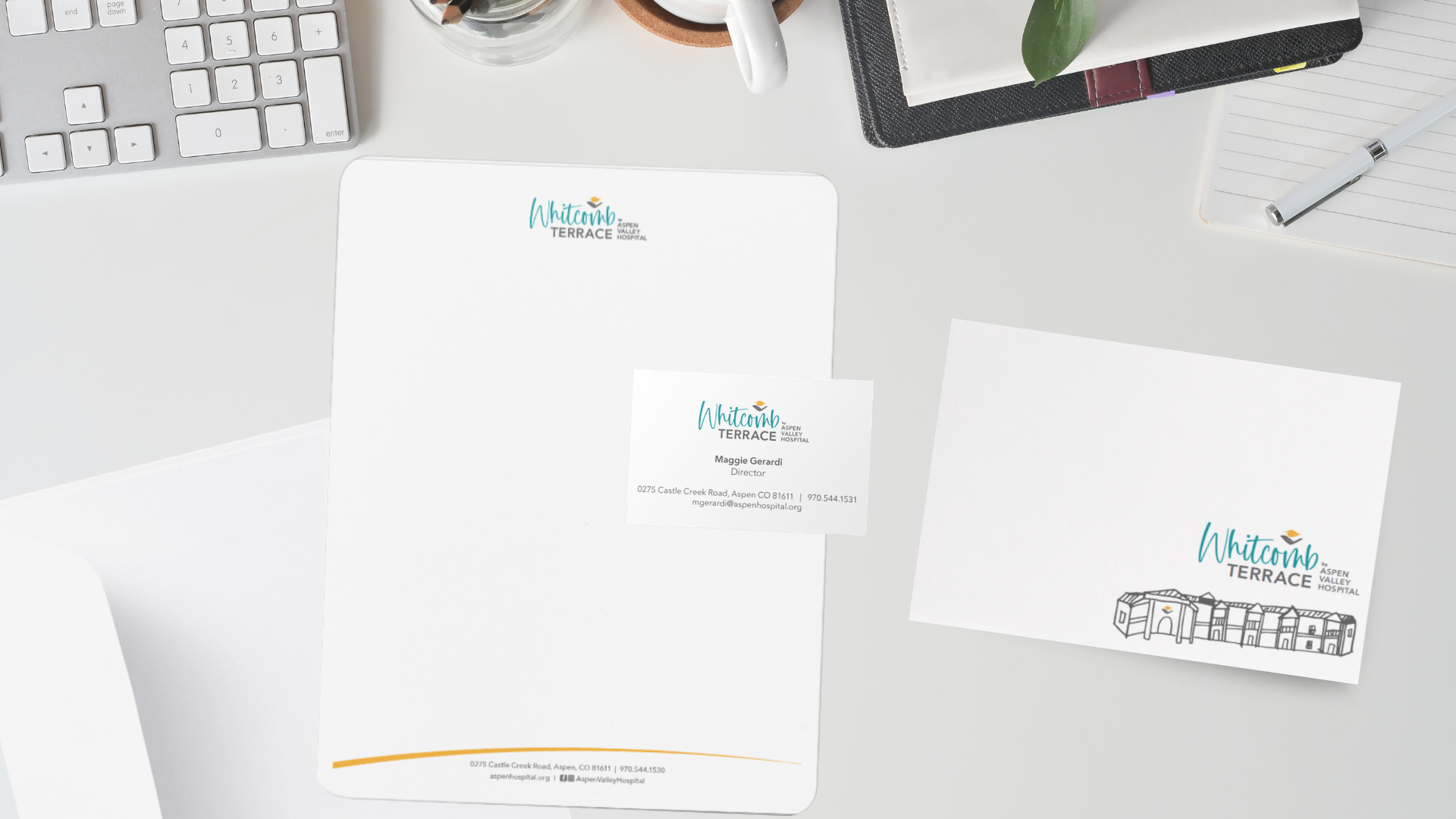 top view of a desk with a keyboard and an assorment of letterheads, envelopes, and notecards.