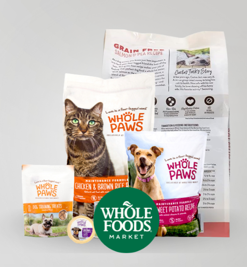 Display of Whole Foods Market pet food products including cat and dog food bags, treats, and a container of pet food with the Whole Foods Market logo.
