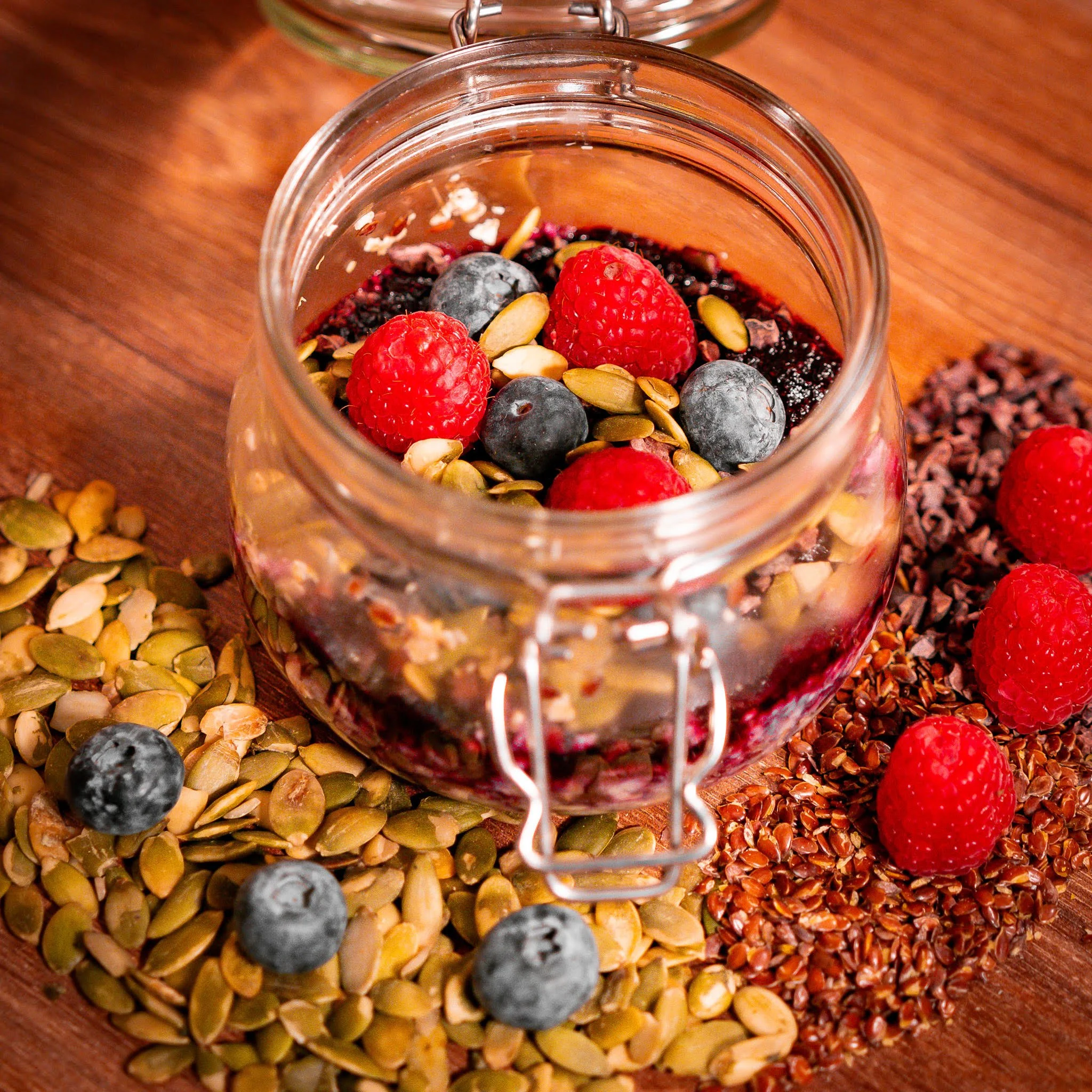 Oatmeal im Glas mit Himbeeren, Heidelbeeren und Kernen