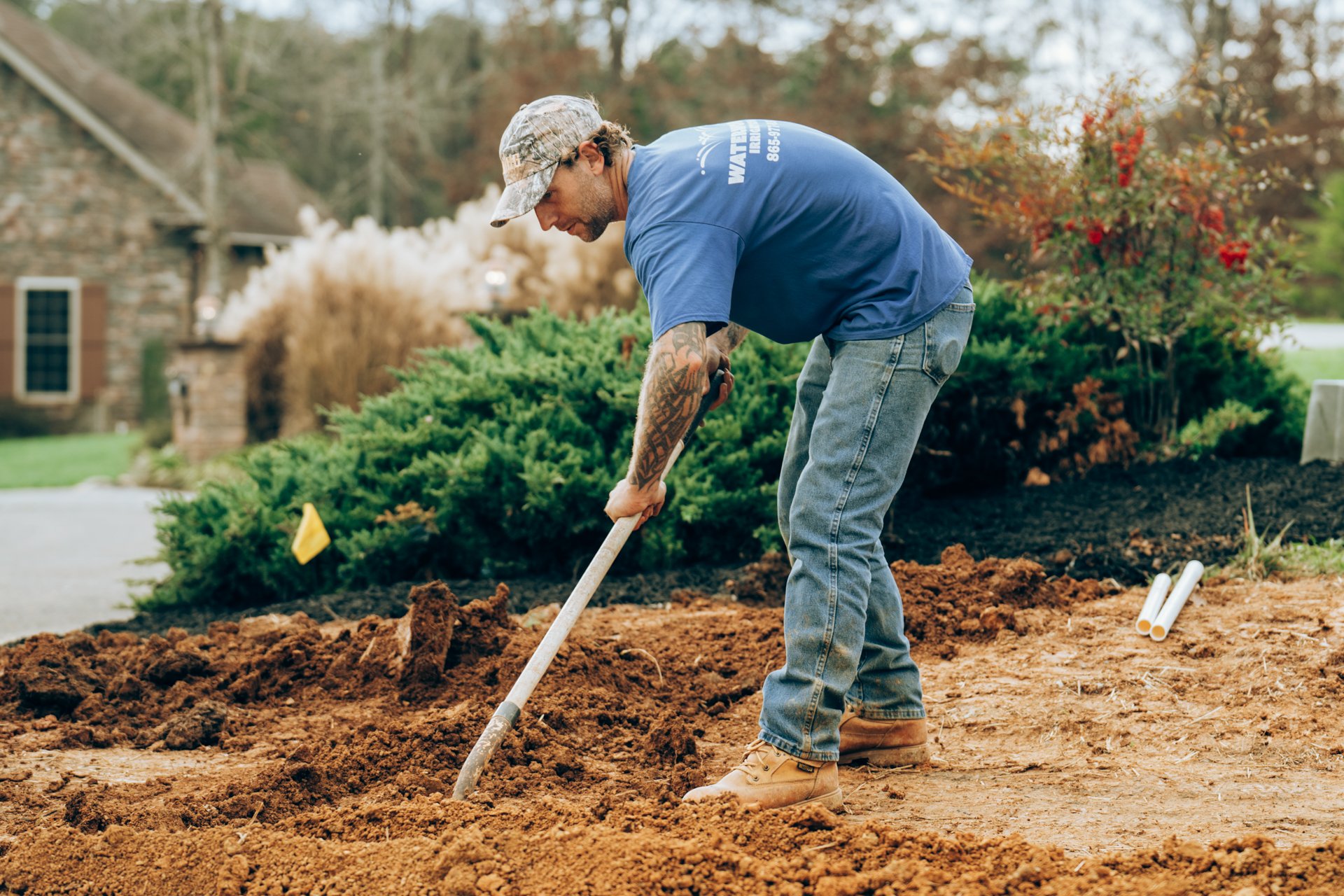 Man planting or working with soil in a garden outdoors.