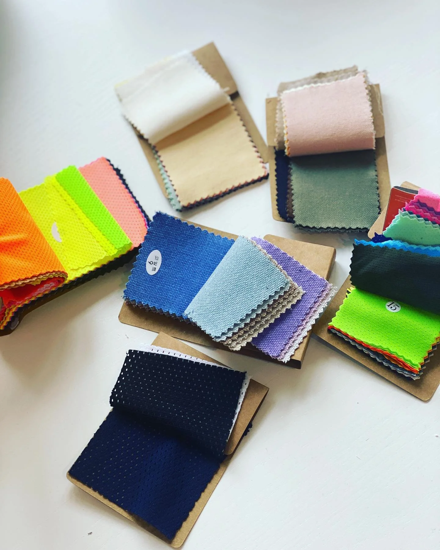 Various fabric swatches in different colors and textures displayed on cardboard samples.