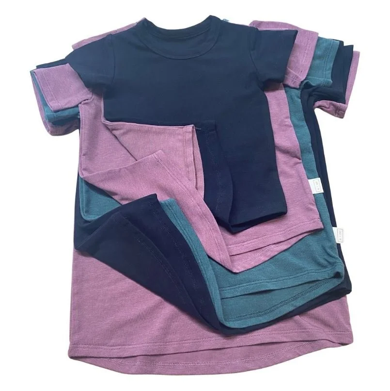 Multiple folded t-shirts in various colors, including navy blue, purple, and teal, arranged on top of each other.