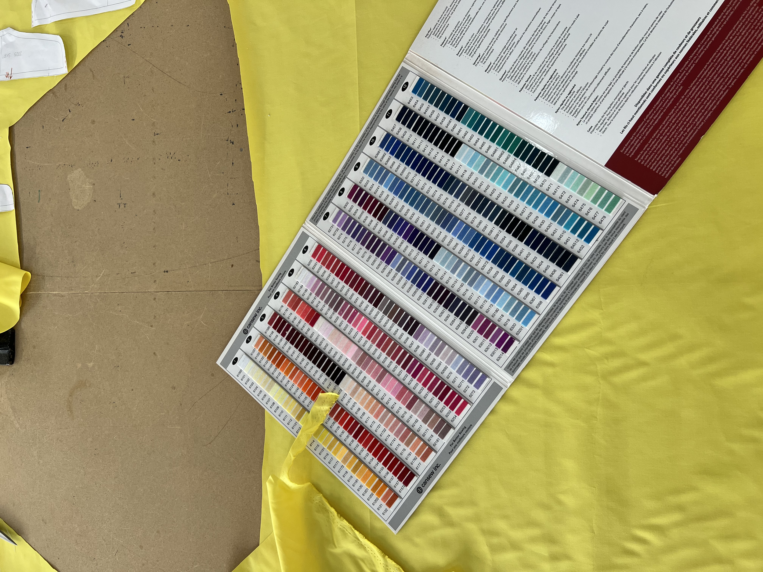 Color matching guide with numerous shade samples arranged in rows on a board, lying on a yellow surface.