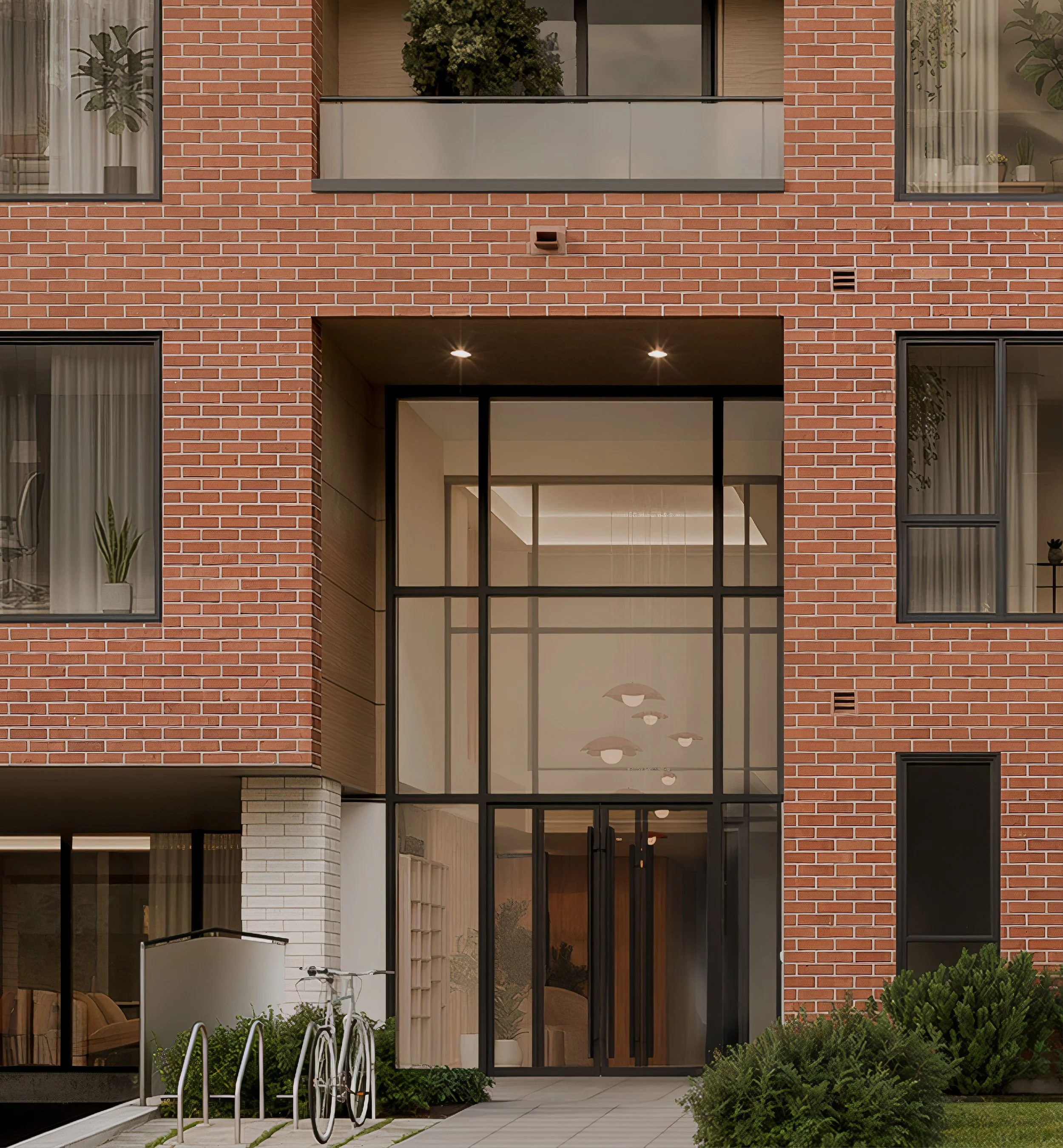 Modern apartment building with large glass entrance, brick facade, and balcony with plants.