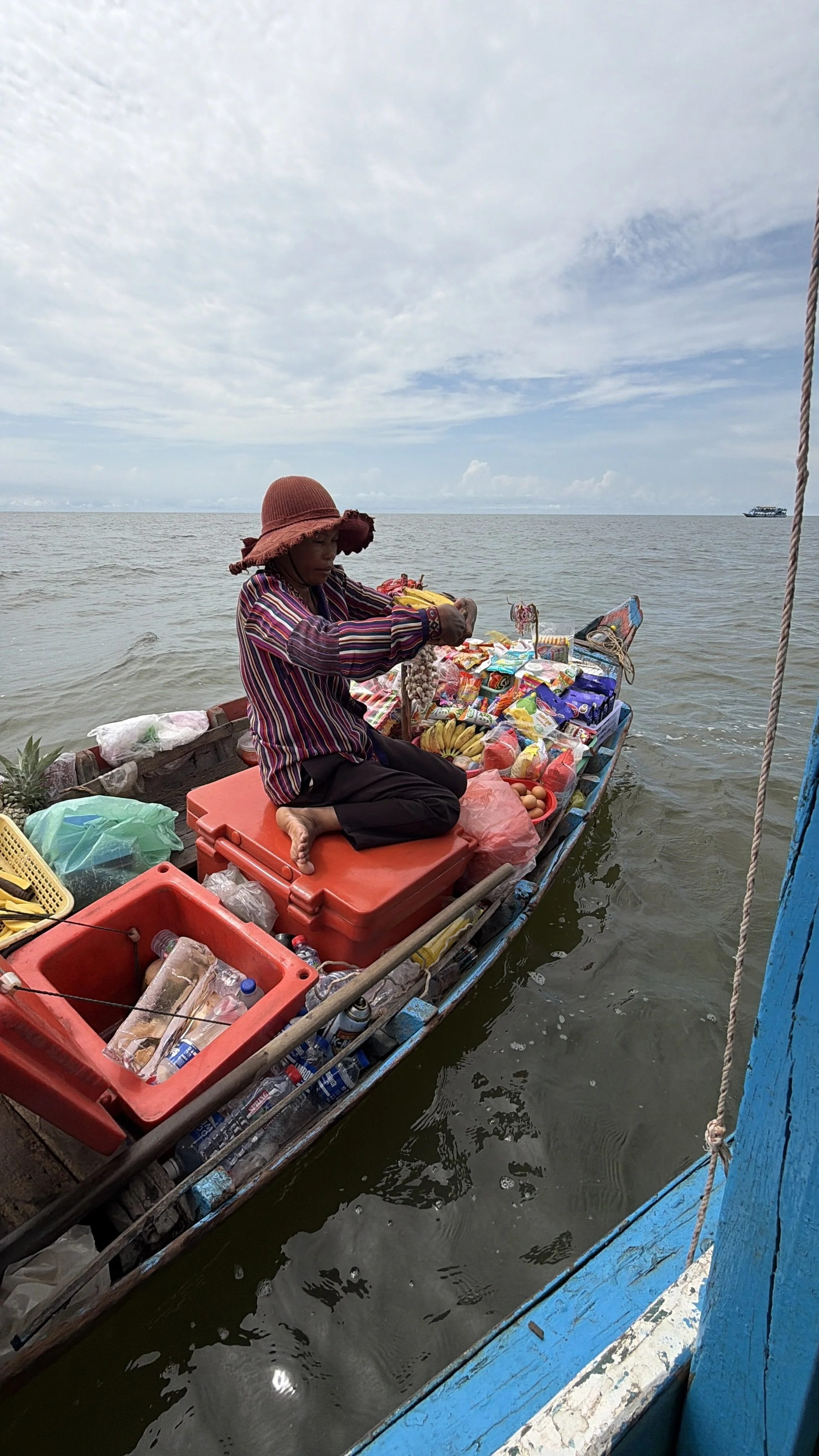 A local vendor with a floating shop on Tonle Sap Lake, Cambodia