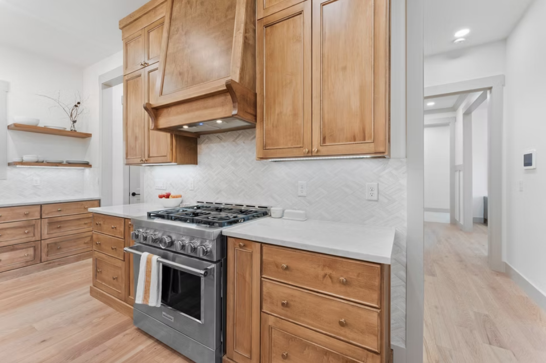 Kitchen with wooden cabinets, a stainless steel oven, and white countertops.