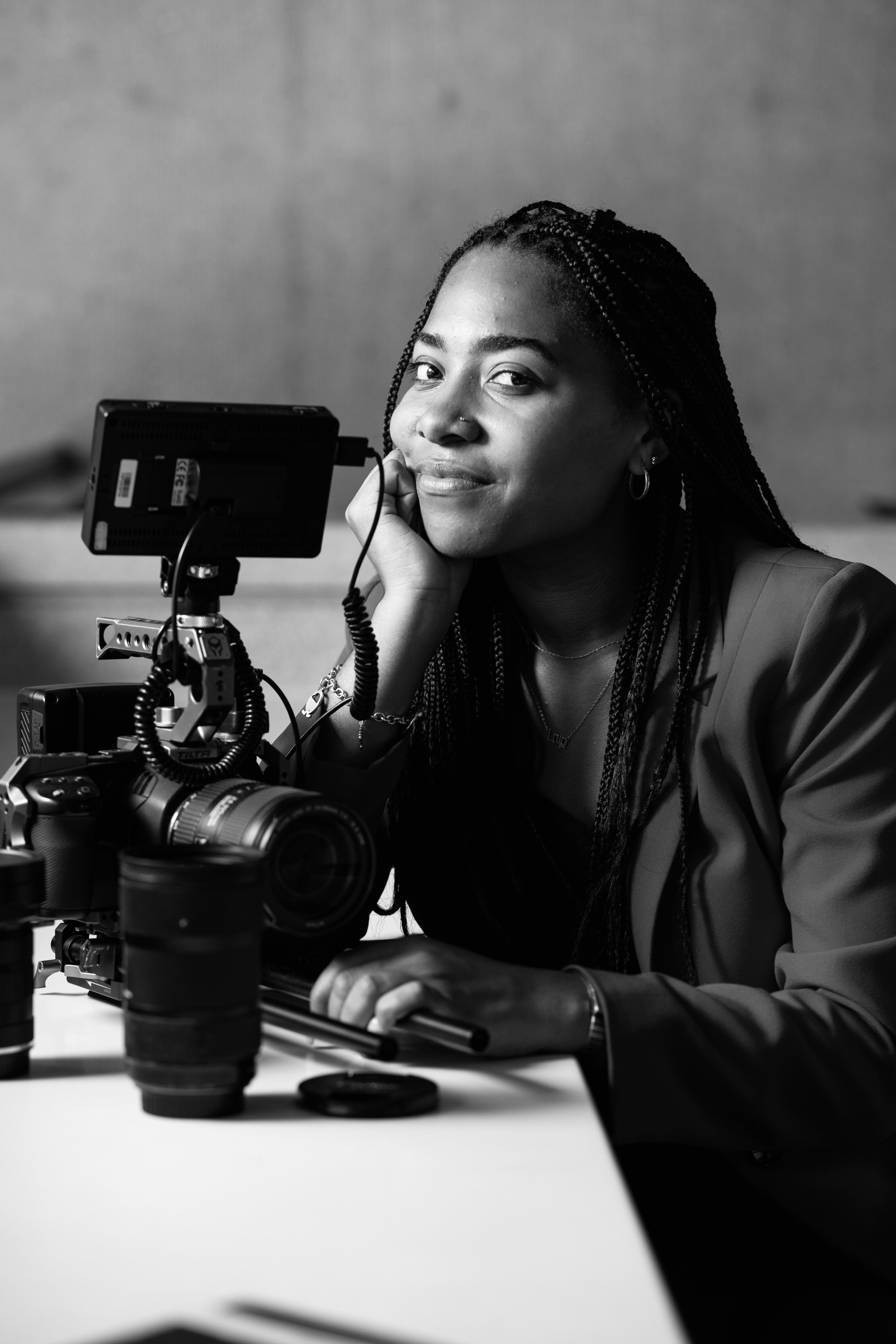 Close-up of a smiling woman with black hair next to a film camera.