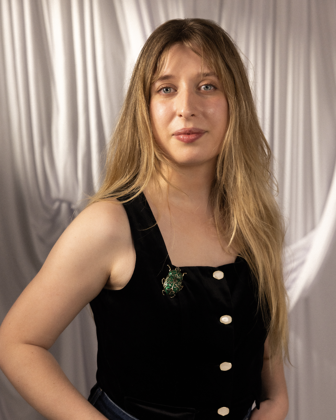 A woman with long blonde hair in a black shirt.