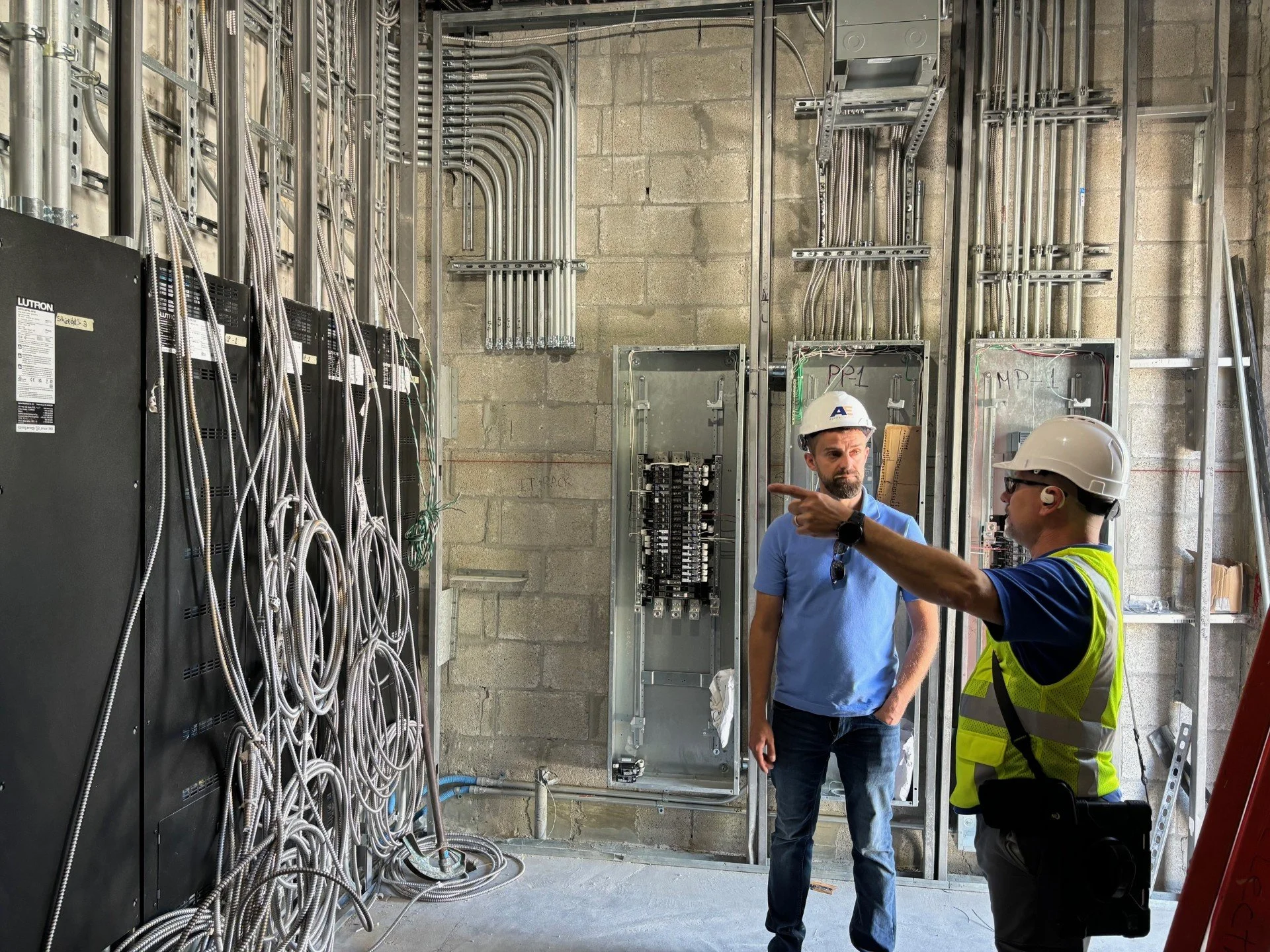 Apollo Electric PM on-site with team, conducting a quality check.